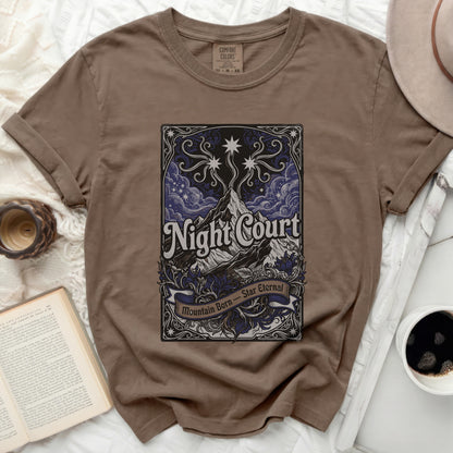 Brown t-shirt with "Night Court Mountain Born Star Eternal" text and celestial design.