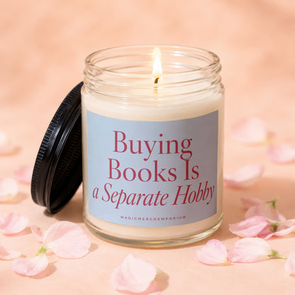 Candle labeled "Buying Books Is a Separate Hobby" with a lit wick and black lid.