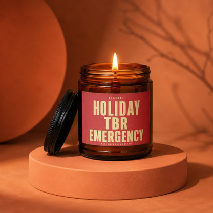 Amber jar candle with lit flame, displaying "Holiday TBR Emergency" text.