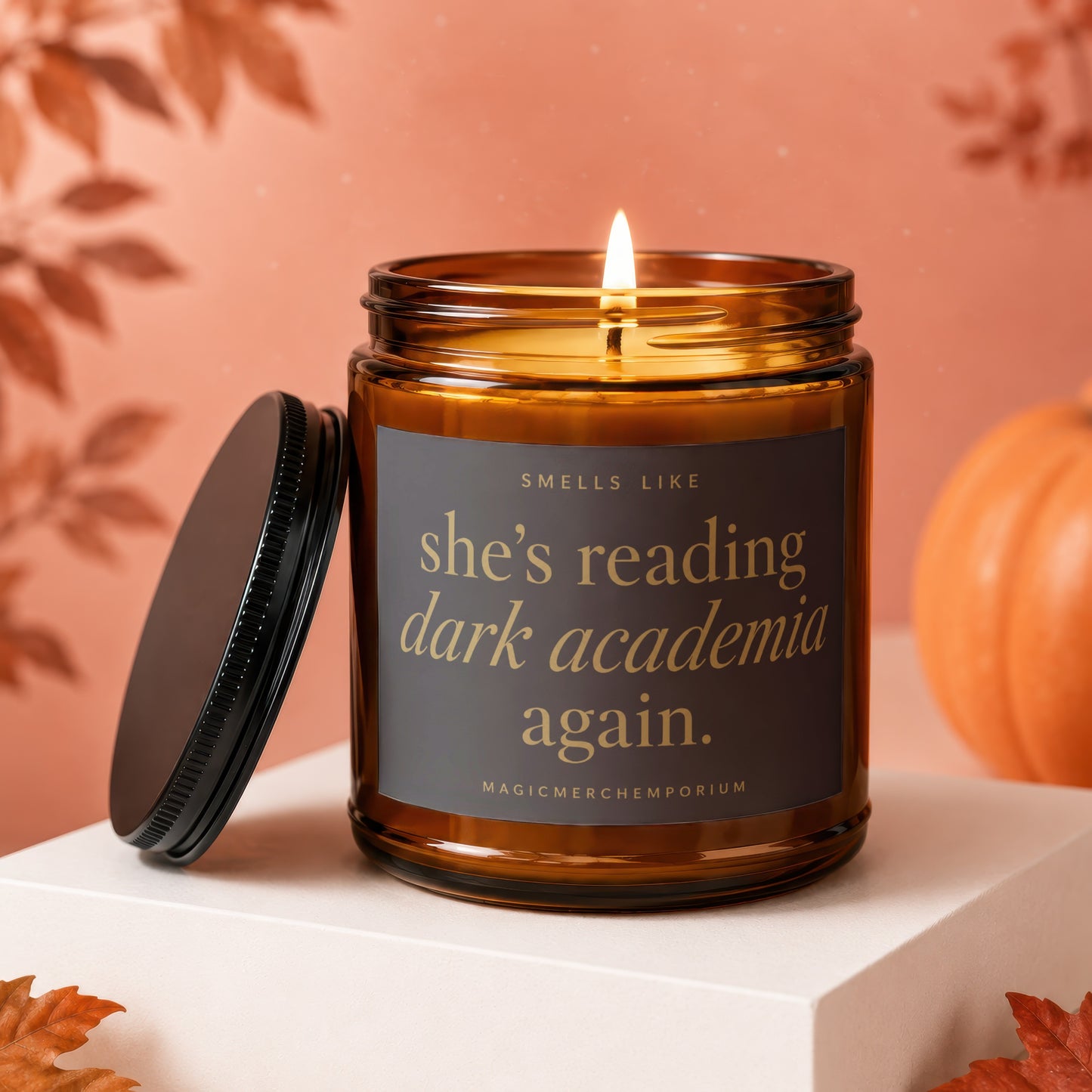 Amber jar candle with lid off, reading "She's reading dark academia again."