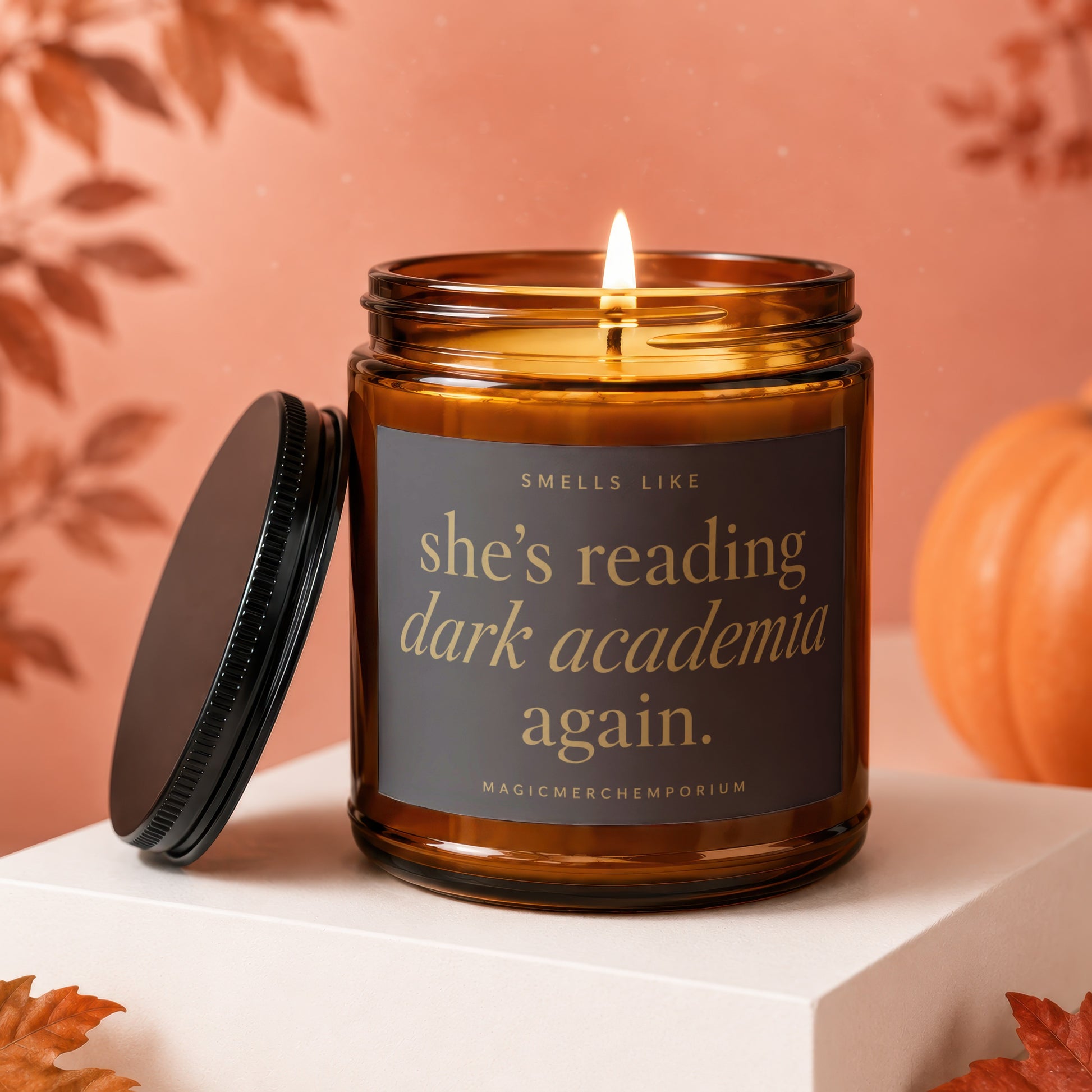 Amber jar candle with lid off, reading "She's reading dark academia again."