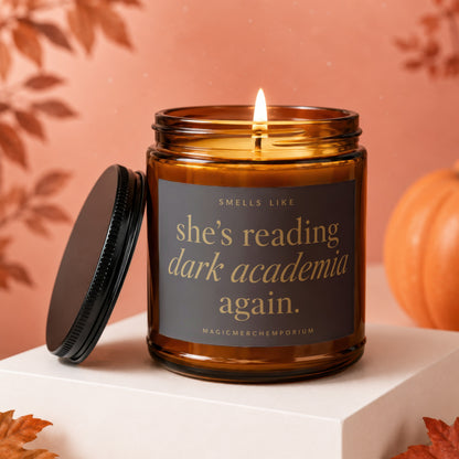 Amber jar candle with lid off, reading "She's reading dark academia again."