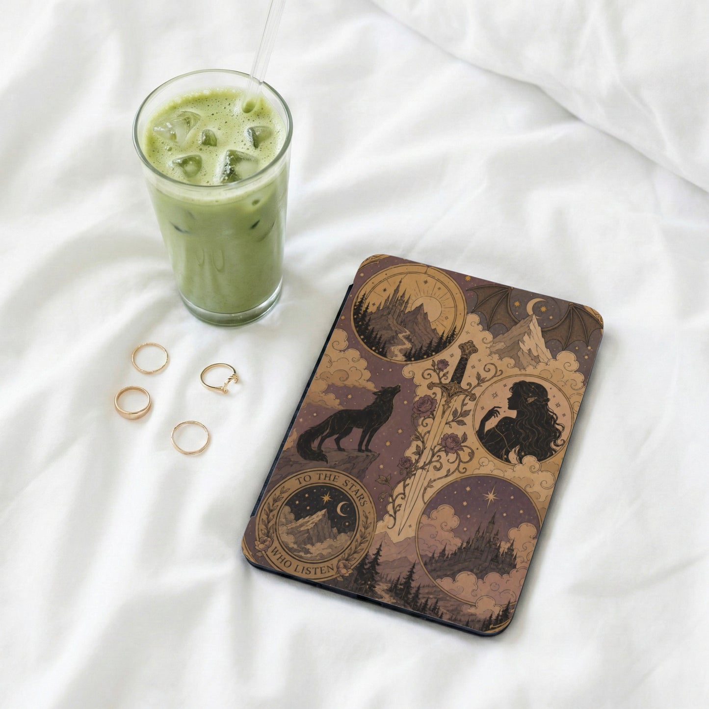 Book cover with wolf, sword, and castles, next to a glass of iced green tea.