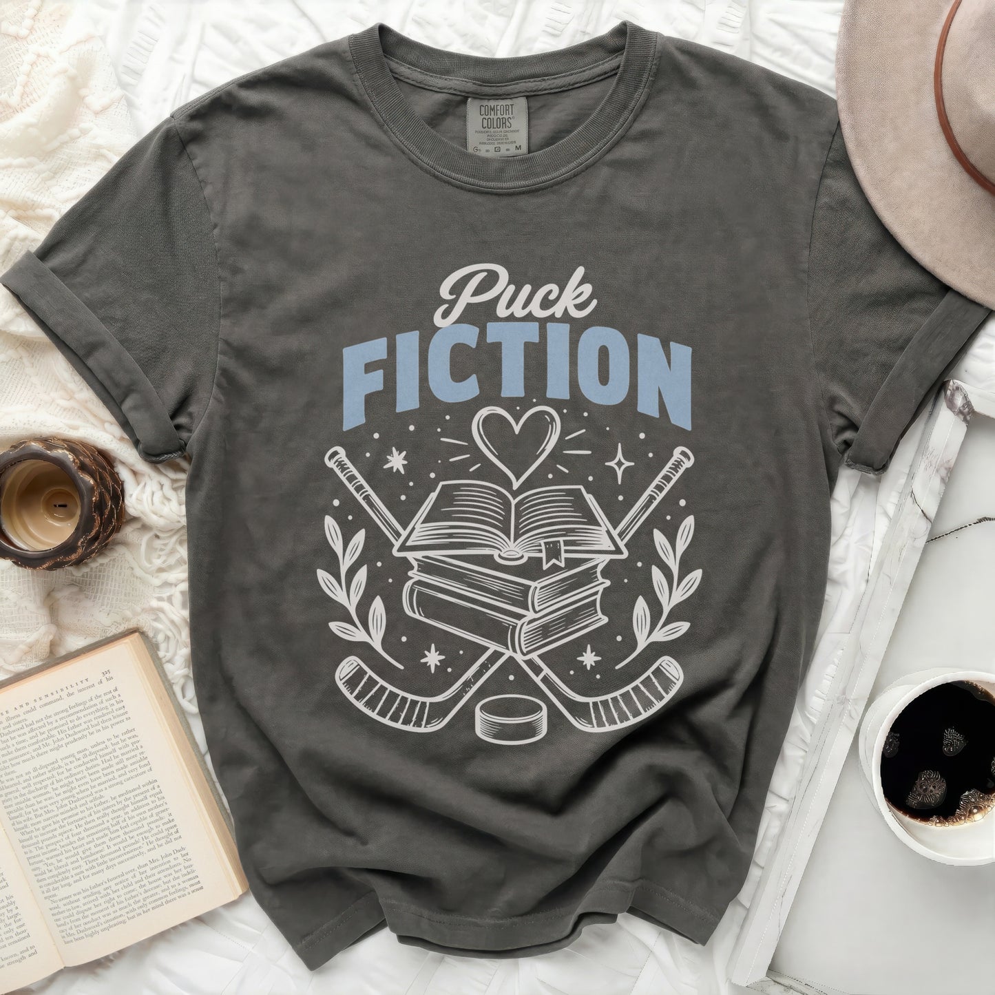 T-shirt with books, hockey sticks, and "Puck Fiction" text.