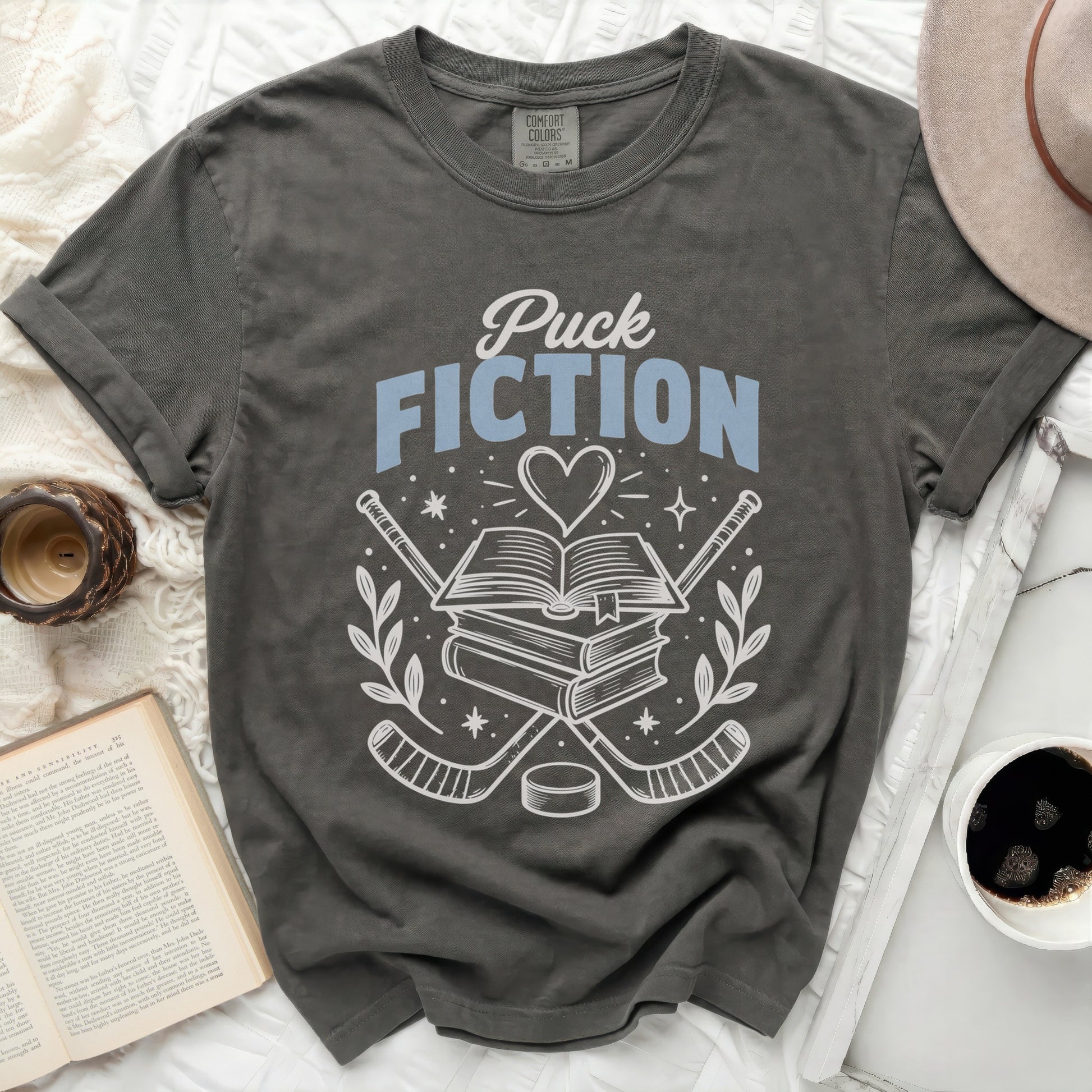 T-shirt with books, hockey sticks, and "Puck Fiction" text.