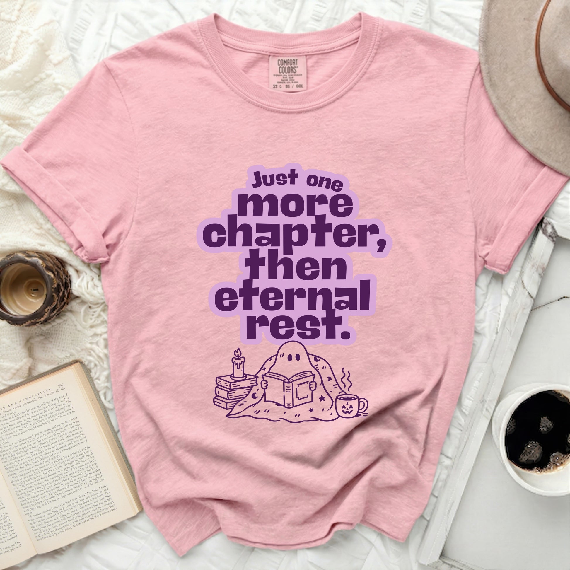 Pink t-shirt with ghost reading book and text "Just one more chapter, then eternal rest."