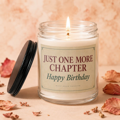 Lit candle with label "Just One More Chapter Happy Birthday" on a peach background.