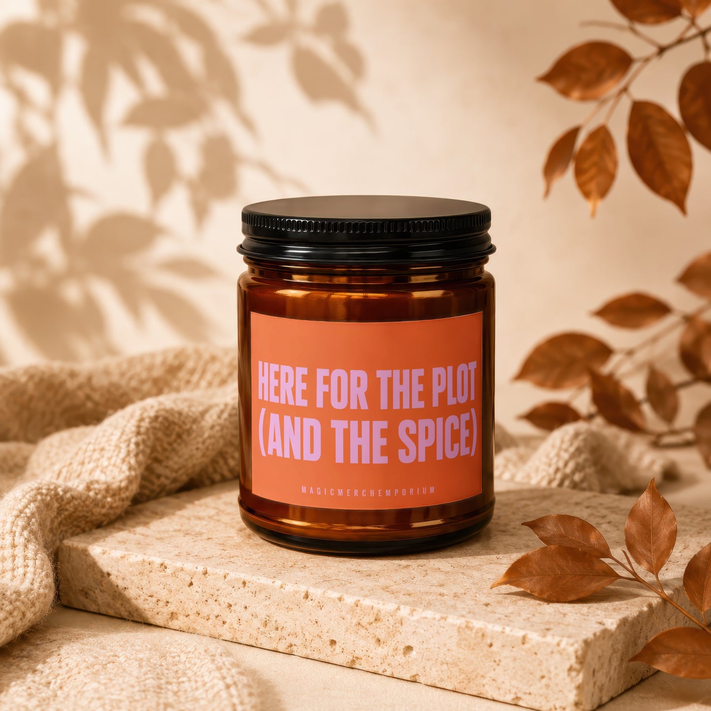 Amber jar candle with orange label saying "HERE FOR THE PLOT (AND THE SPICE)".