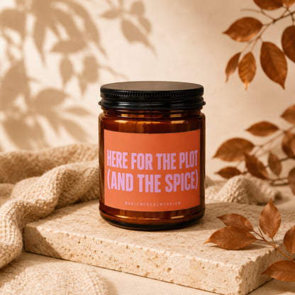 Amber jar candle with orange label saying "HERE FOR THE PLOT (AND THE SPICE)".