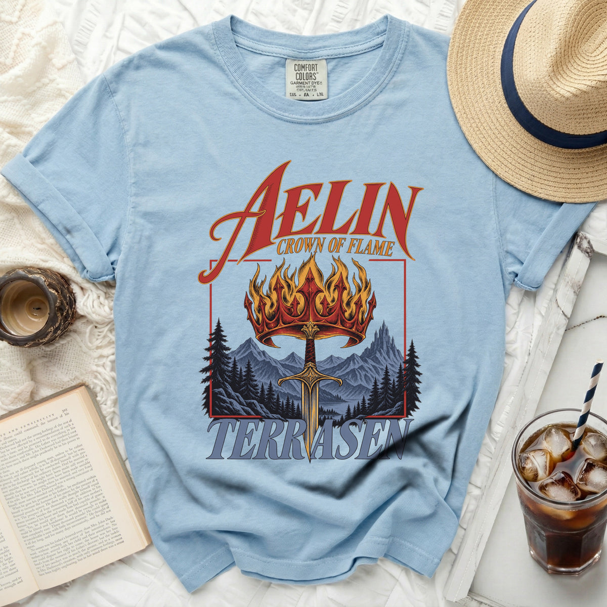 Light blue t-shirt with "Aelin Crown of Flame" and "Terrasen" graphic.