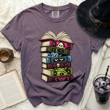 Purple t-shirt with spooky Halloween-themed book stack graphic.