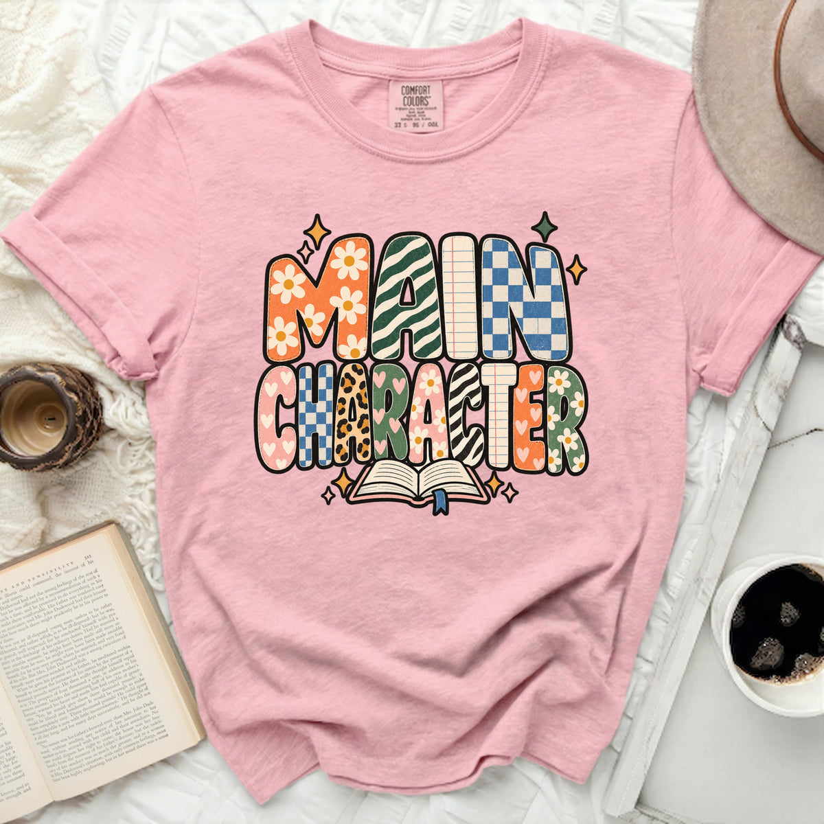 Pink t-shirt with "MAIN CHARACTER" text in retro, patterned letters.