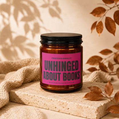 Amber jar candle with a pink label that reads "UNHINGED ABOUT BOOKS".