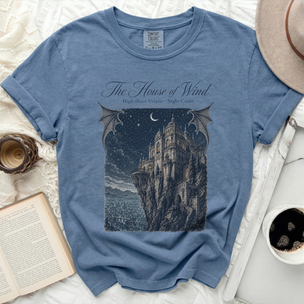 Blue t-shirt with "The House of Wind High above Velaris Night Court" graphic.