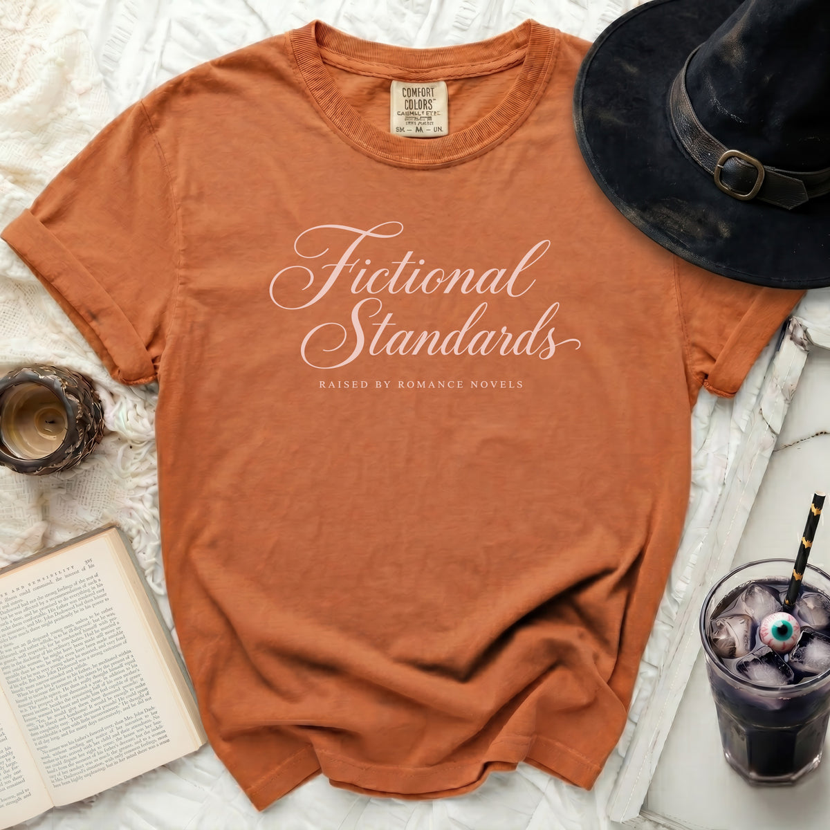 Orange t-shirt with "Fictional Standards Raised by Romance Novels" text.