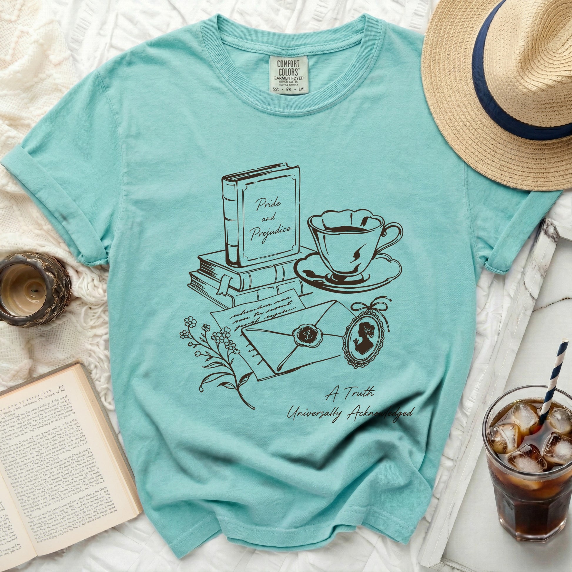 Teal t-shirt with "Pride and Prejudice" book, teacup, and envelope graphic.