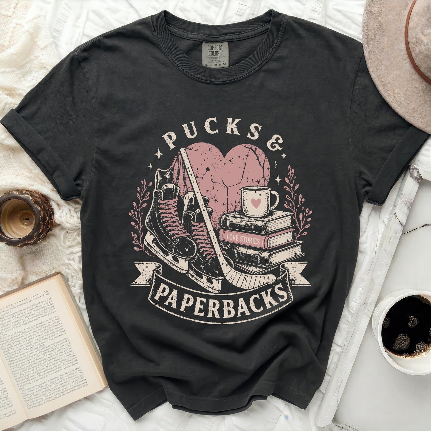 Black t-shirt with "Pucks & Paperbacks" graphic and books.
