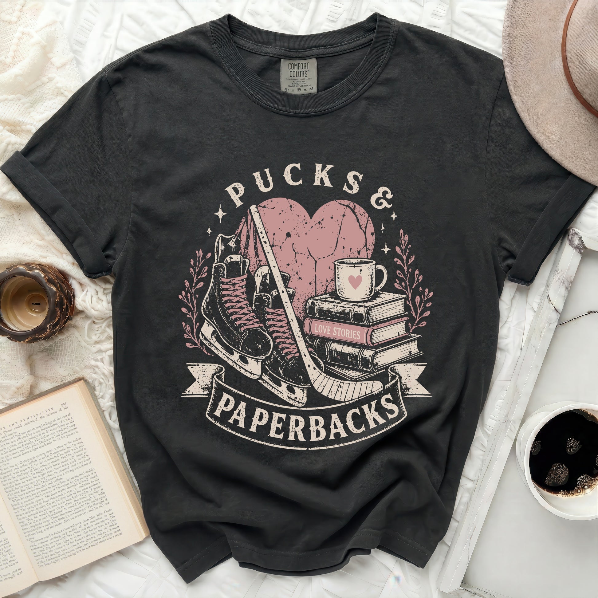 Black t-shirt with "Pucks & Paperbacks" graphic and books.