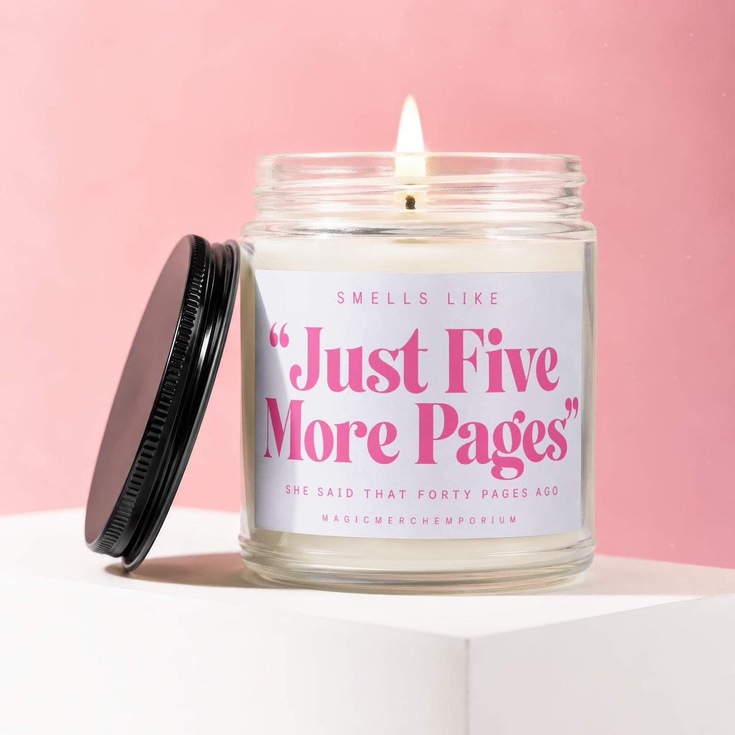 Scented candle with label "Just Five More Pages" on a pink background.