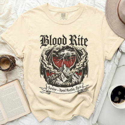 Cream t-shirt with "Blood Rite" graphic of mountains, storm, and dragon wings.