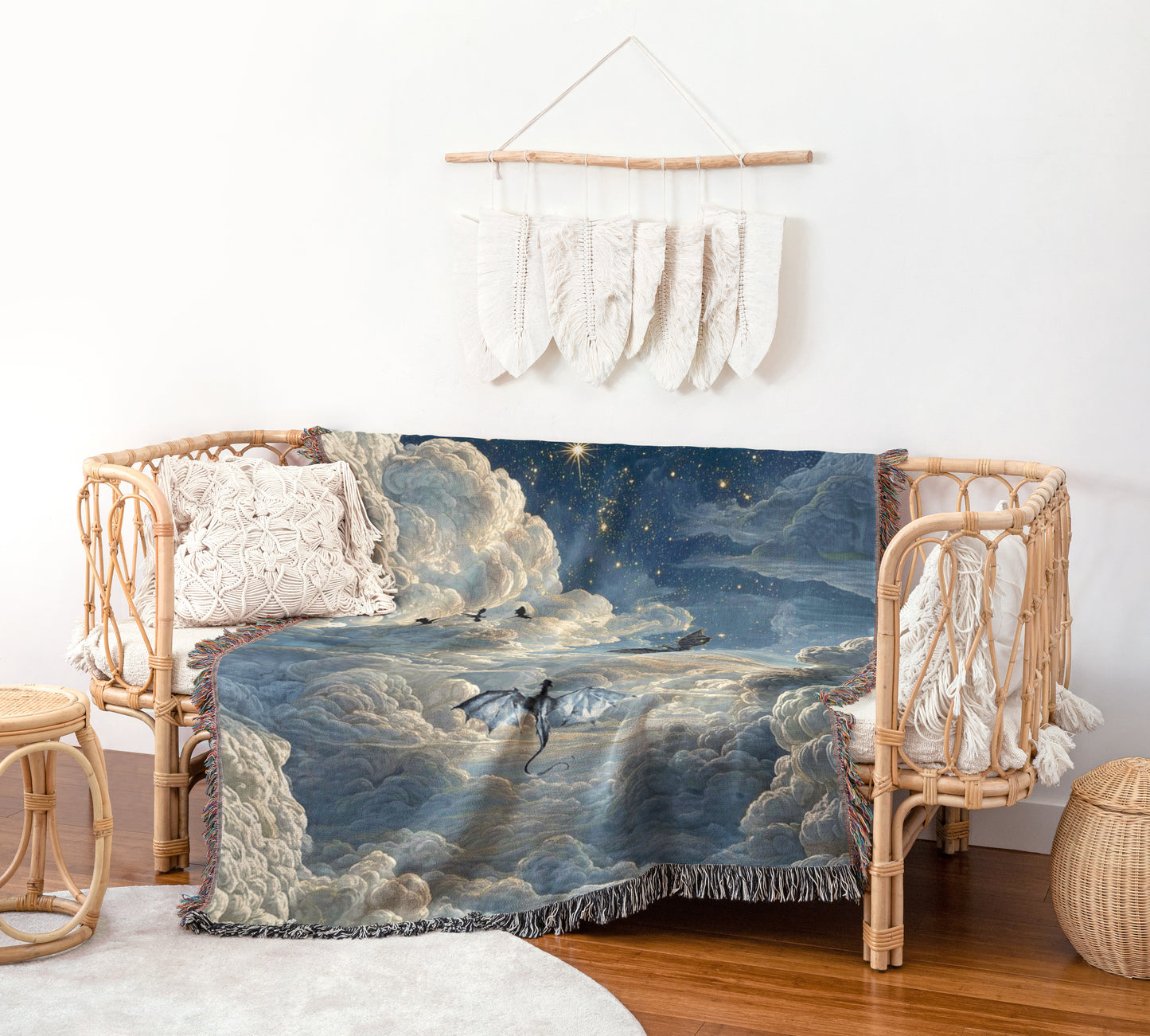 a cozy living room with a woven bench and a woven side table. The bench is adorned with a blanket that depicts a serene night sky with a dragon flying over the clouds. The blanket has a blue and white color scheme, and the dragon appears to be soaring through the sky. The room is decorated with a hanging feather wall art piece and a woven basket, adding to the overall aesthetic of the space.
