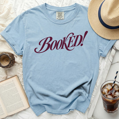 Light blue t-shirt with "BOOKED!" in burgundy cursive font.