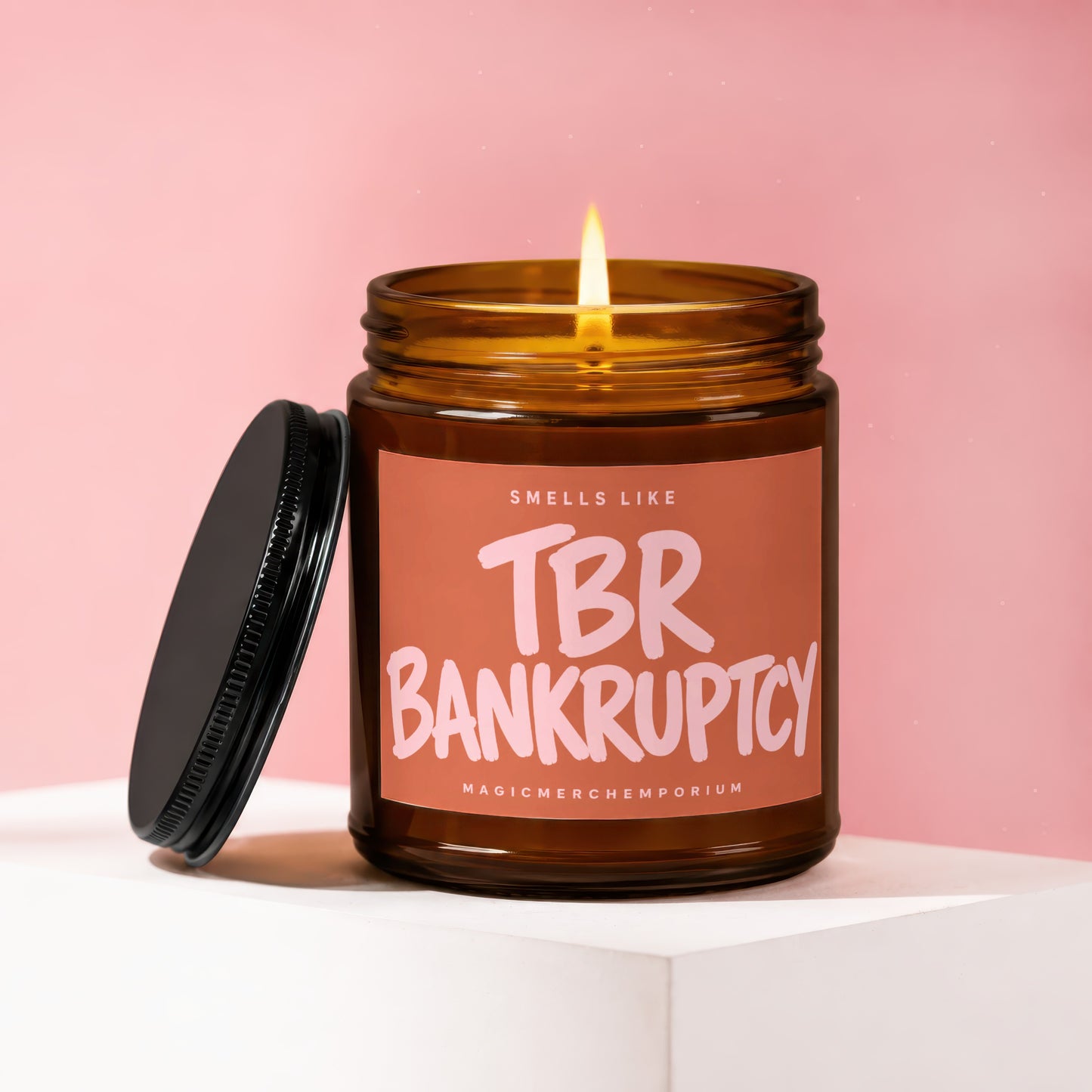Candle with lit wick and "Smells Like TBR Bankruptcy" label.