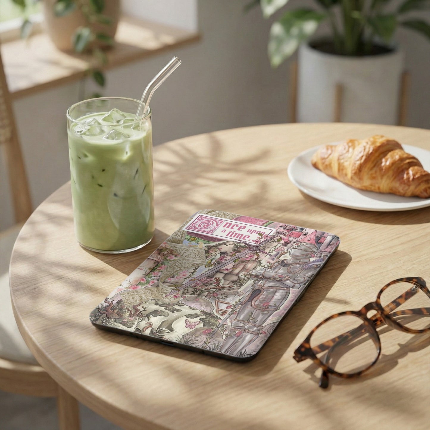 Ipad case with "once upon a time" text and knight illustration rests on a table.