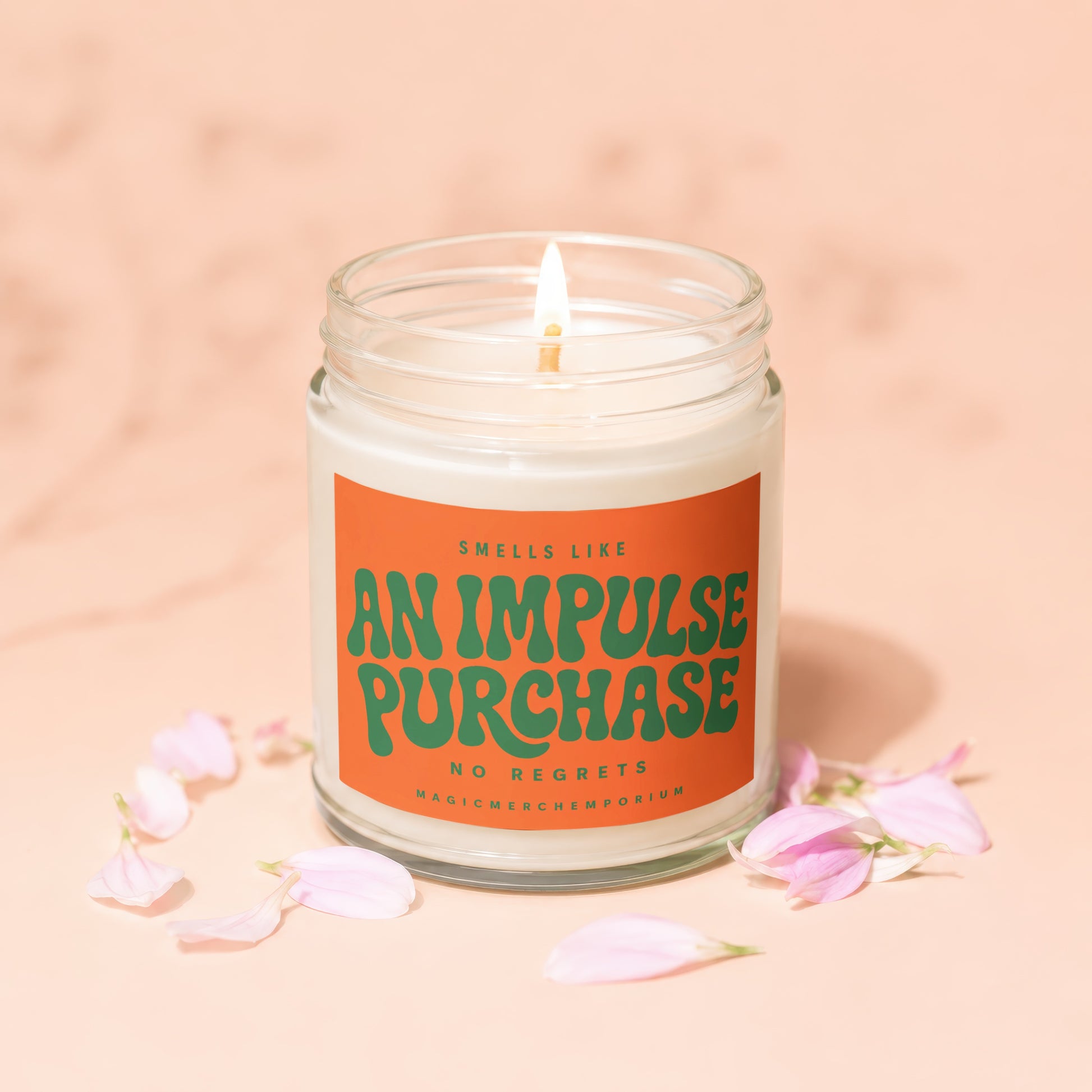 Candle with orange label reading "Smells like an impulse purchase. No regrets. MagicMerchEmporium."