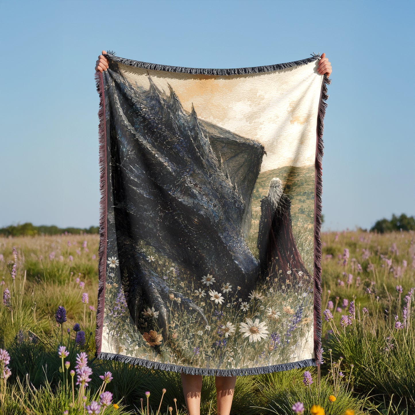 A person is holding up a large tapestry or blanket with a painting of a woman in a field of flowers and mountains in the background.