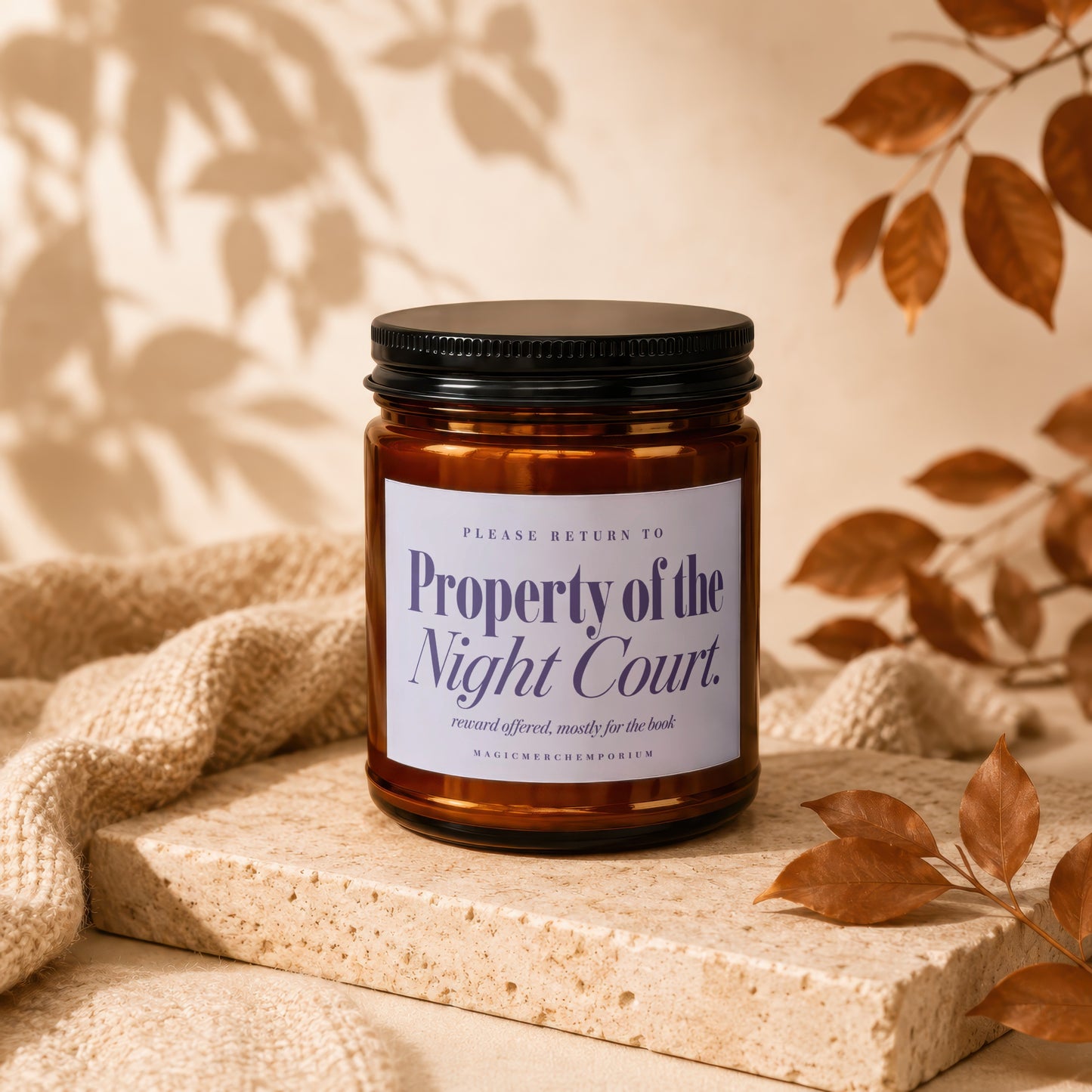 Amber jar candle with black lid labeled "Property of the Night Court."