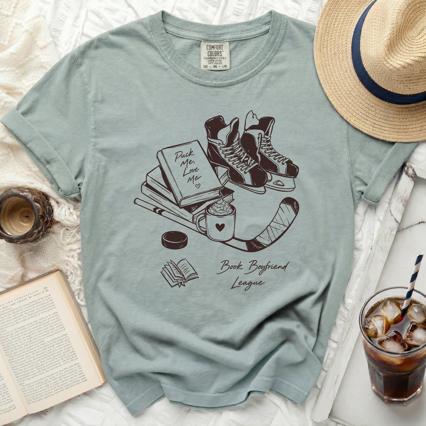 T-shirt with "Puck Me Love Me Book Boyfriend League" graphic and hockey skates.