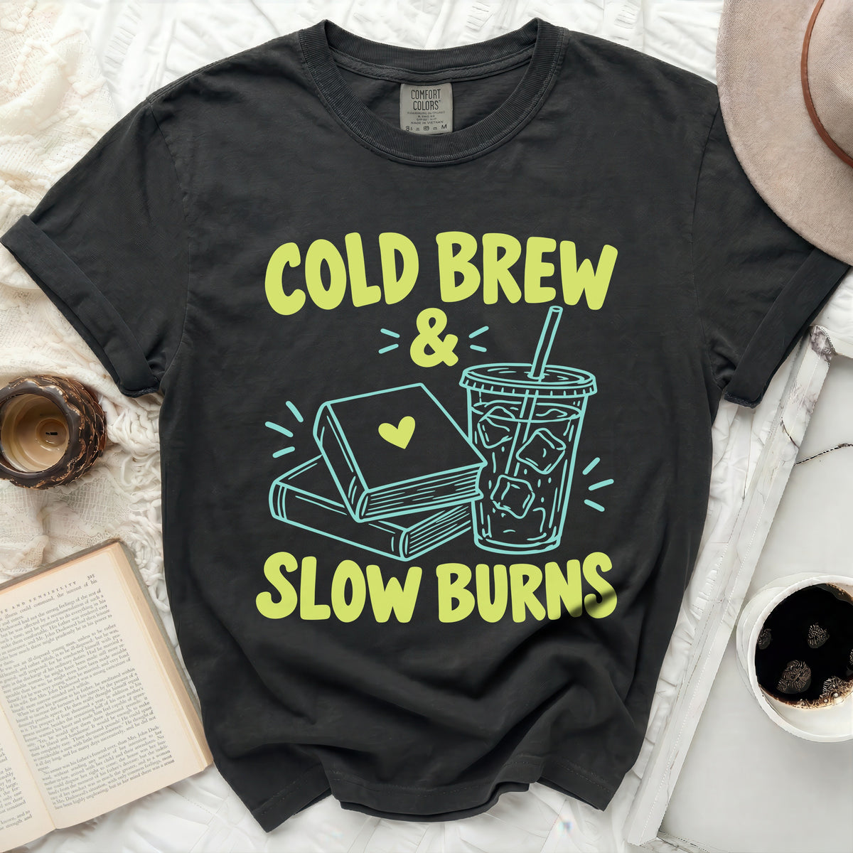 T-shirt with "Cold Brew & Slow Burns" text, books, and iced coffee cup graphic.
