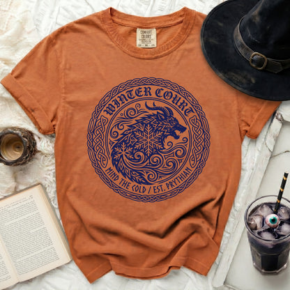 Orange t-shirt with blue "Winter Court" wolf and snowflake graphic.