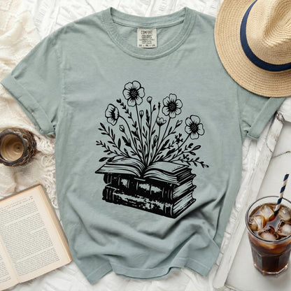 T-shirt with black floral design emerging from stacked books.