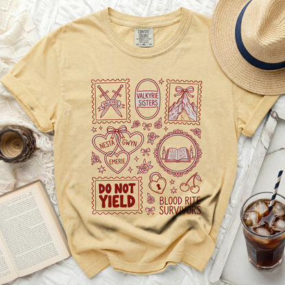 Yellow t-shirt with red graphic design including swords, mountains, hearts, books, and text.