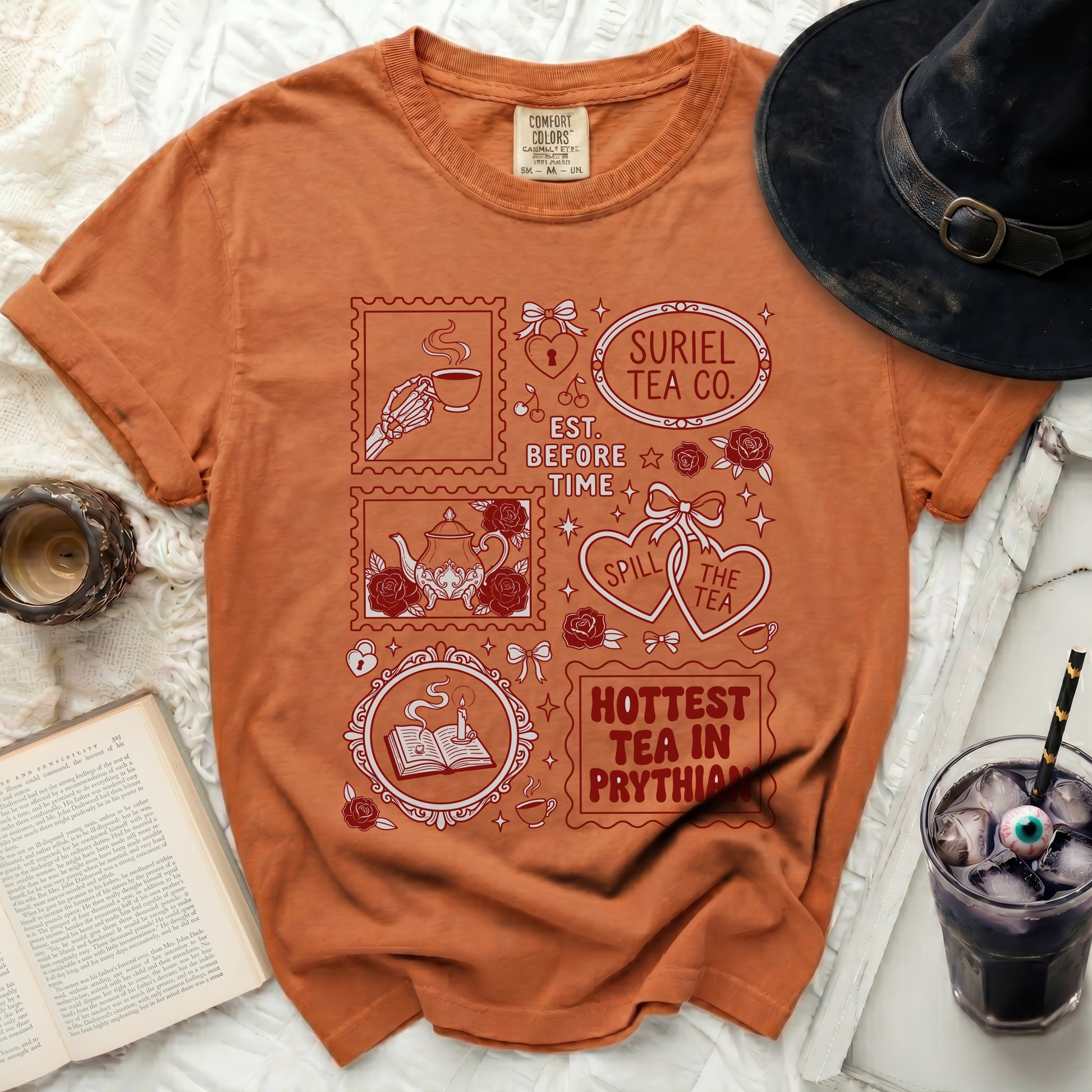 Orange t-shirt with red graphic designs and text: Suriel Tea Co., Est. Before Time, Spill the Tea, Hottest Tea in Prythian.