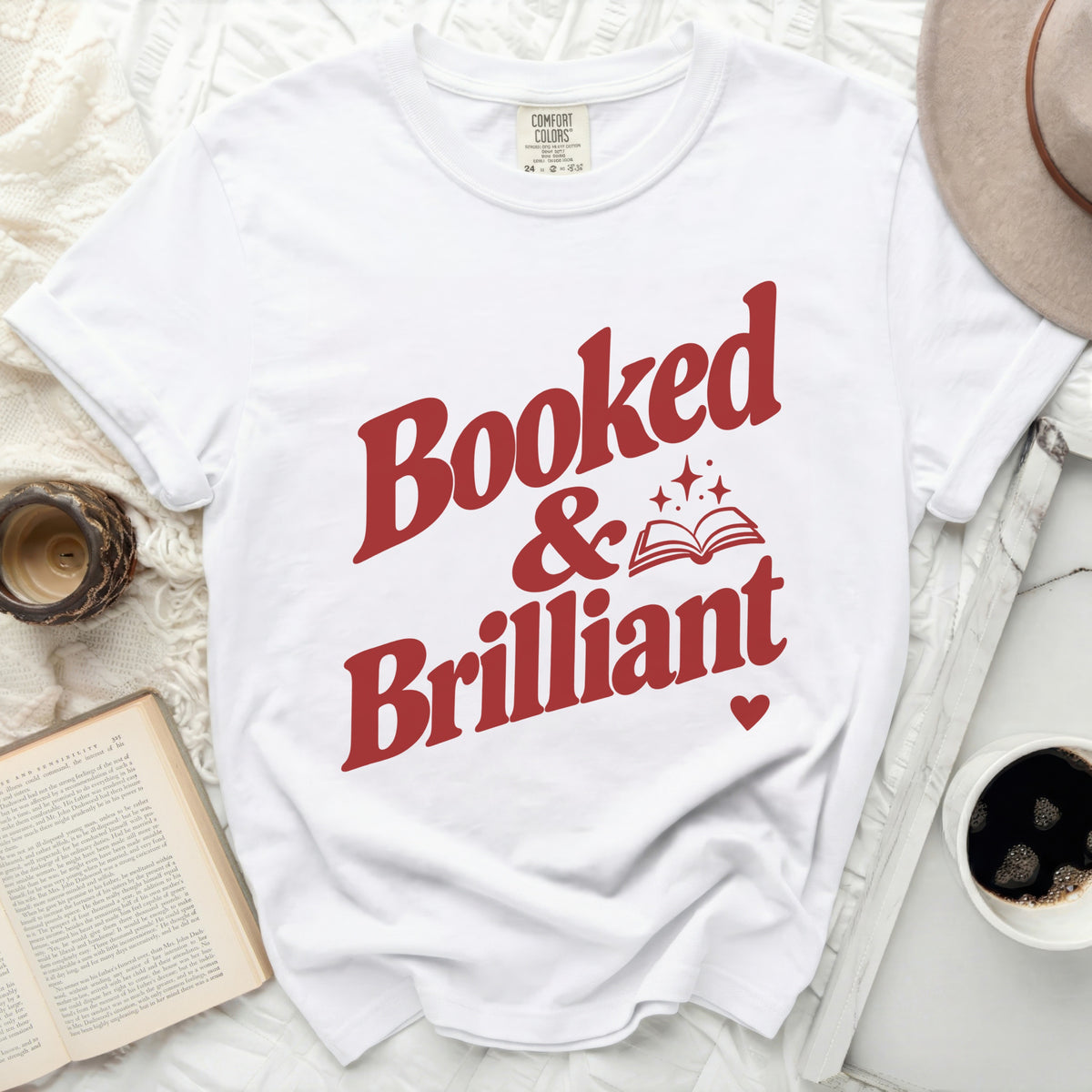 White t-shirt with red text "Booked & Brilliant" and an open book graphic.