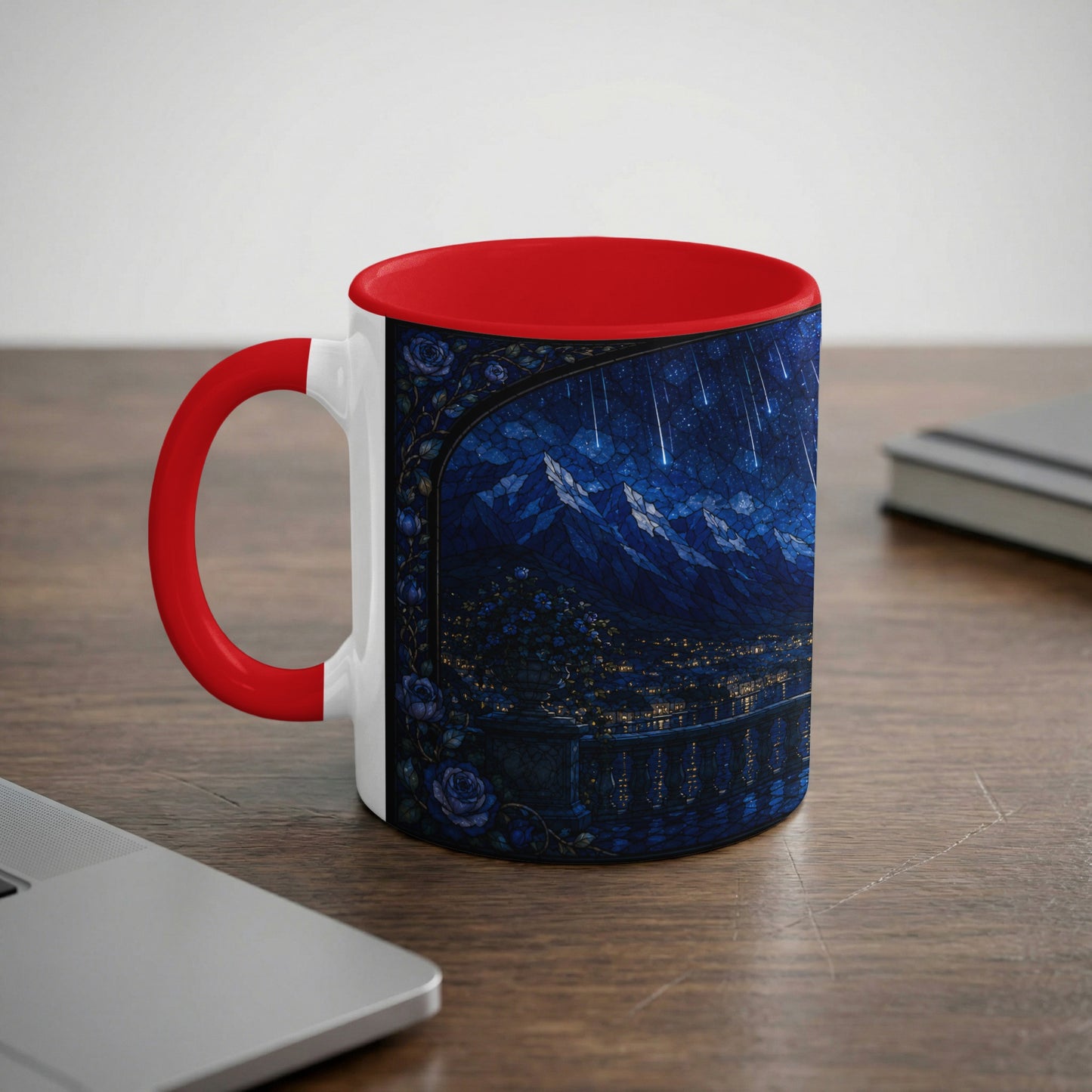 White mug with red handle featuring a stained-glass-style night scene of mountains and city lights.