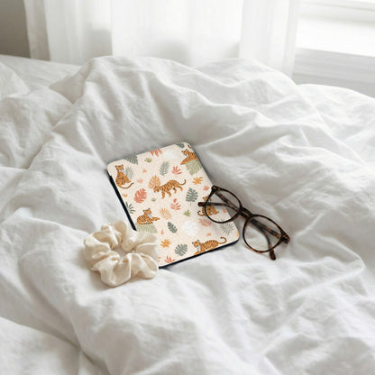 Tiger pattern phone case on white bedding with glasses and scrunchie.
