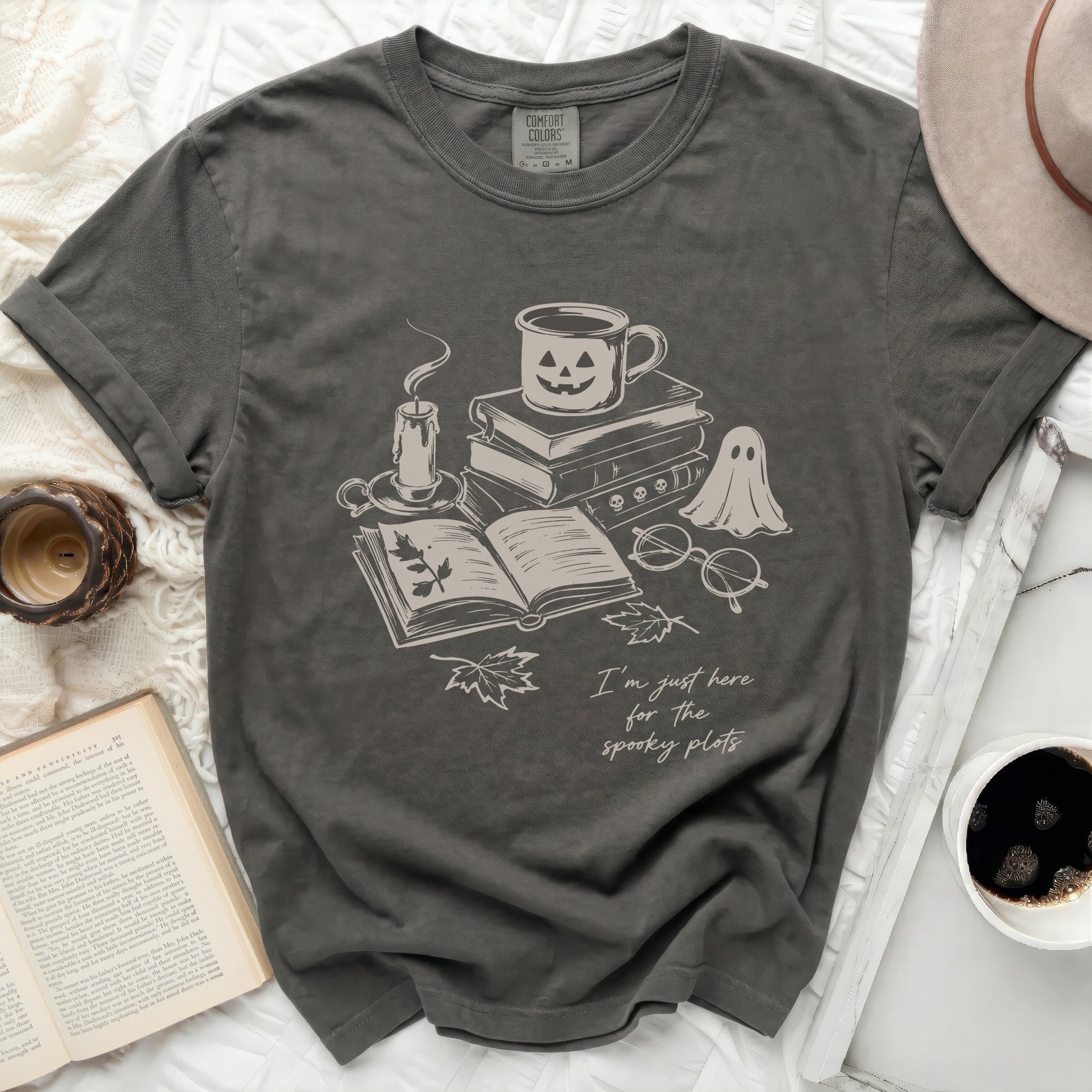 Dark grey t-shirt with a graphic of books, candle, ghost, and text.