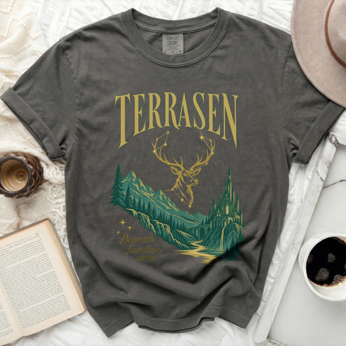 T-shirt with "TERRASEN" and "Beneath familiar stars" text, featuring a deer and castle graphic.