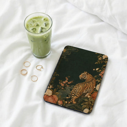 Dark green case with a floral tiger design, next to matcha iced coffee.