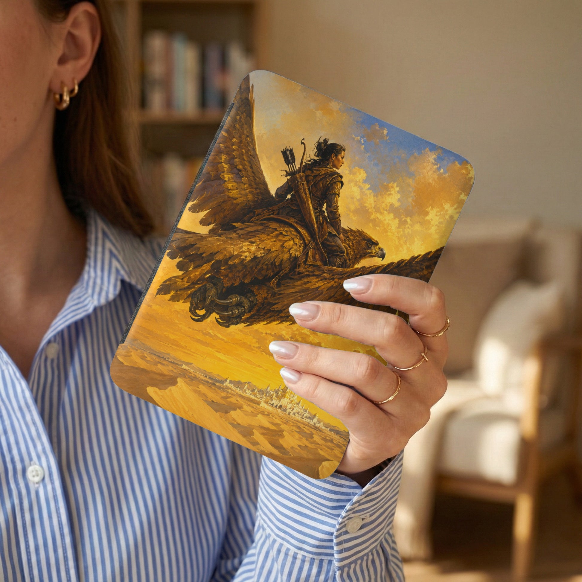 Woman holding an e-reader featuring a warrior riding a bird over a city.