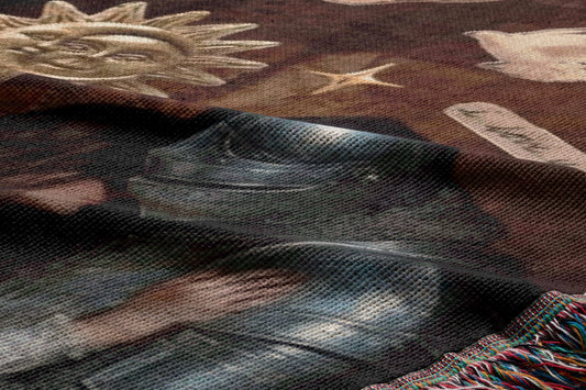 The image is a close-up of a fabric with a metallic texture, featuring a metallic object and a sun-like design.