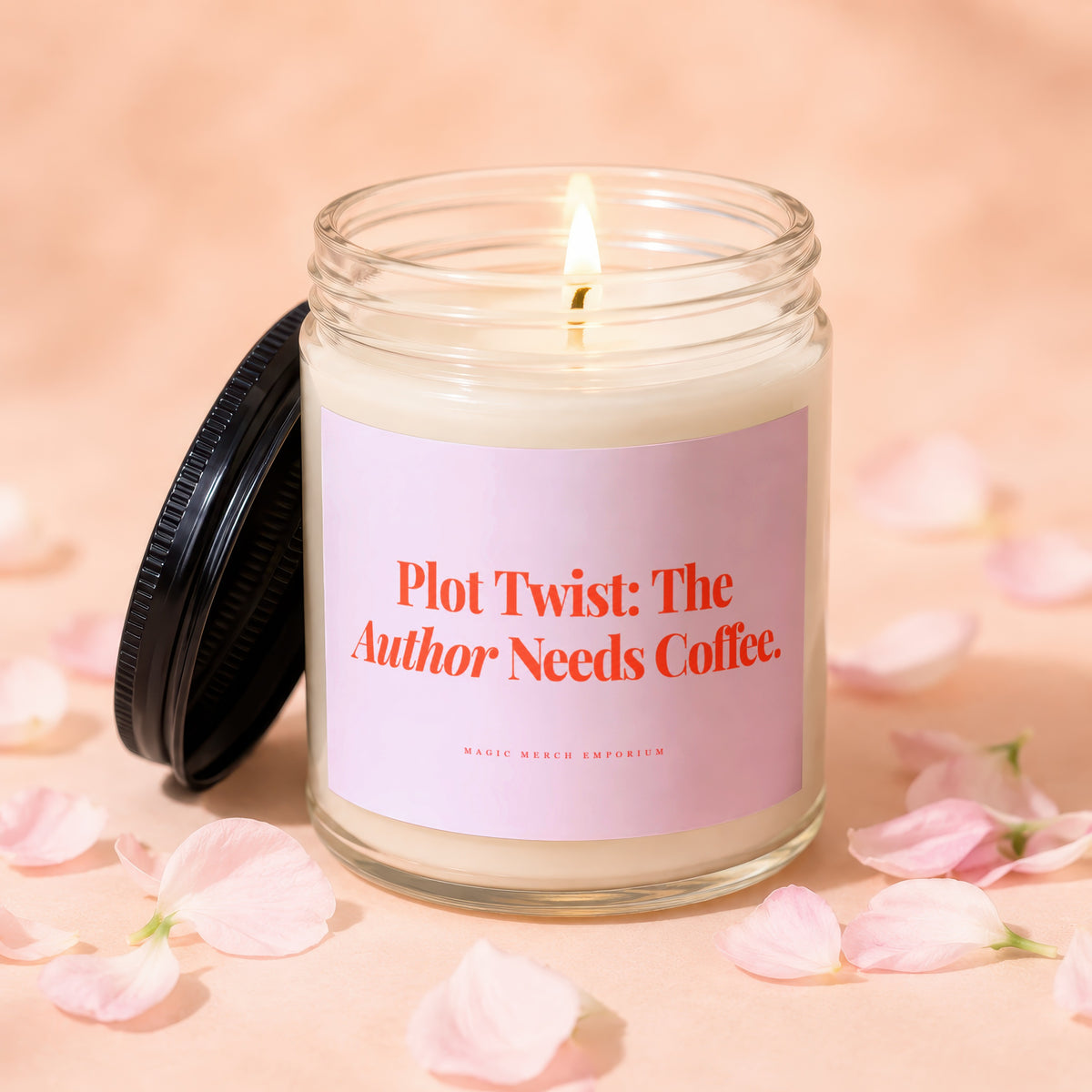 Lit candle with pink label reading "Plot Twist: The Author Needs Coffee."