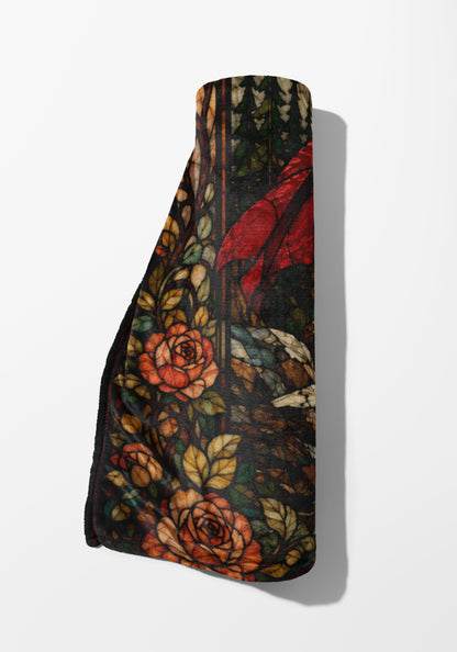 Rolled blanket with stained glass design of roses and leaves.