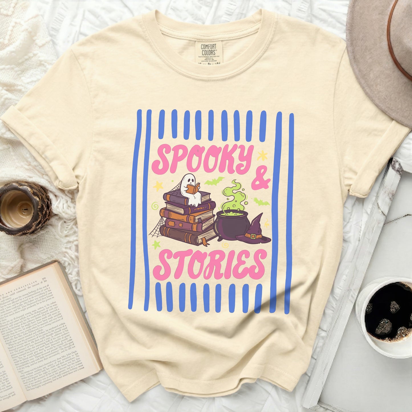 Cream t-shirt with "Spooky & Stories" graphic featuring books, ghost, cauldron and hat.