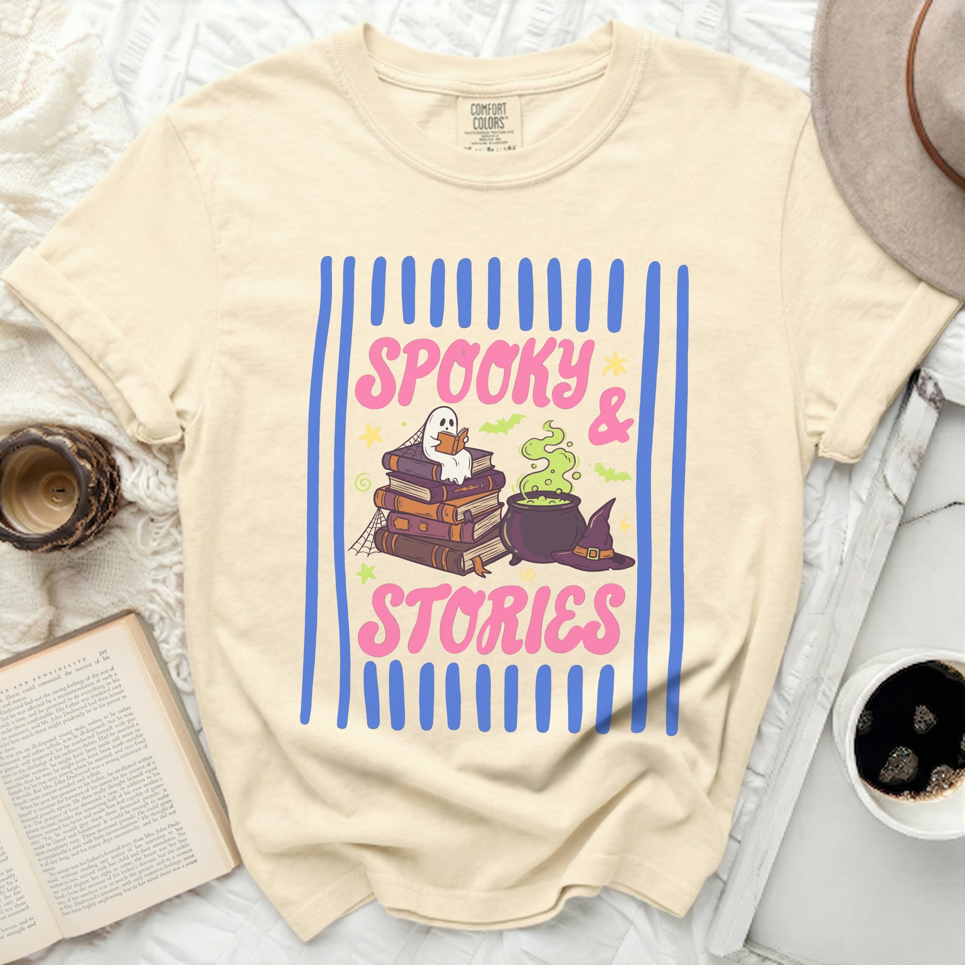 Cream t-shirt with "Spooky & Stories" graphic featuring books, ghost, cauldron and hat.