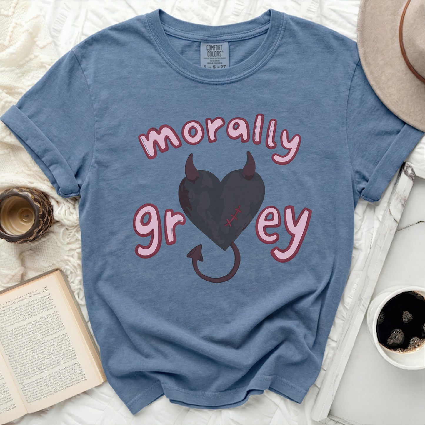 Blue t-shirt with pink "morally grey" text and a heart with devil horns.
